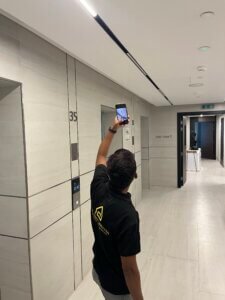 Engineer photographing lift lobby ceiling during a building inspection
